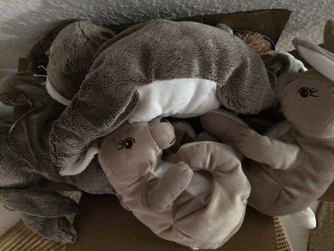 Karton voll mit Stoffhasen und Kaninchen.
